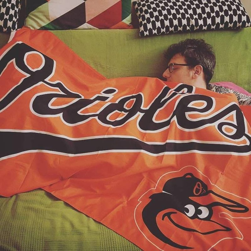 Luca dorme sotto una bandiera arancione dei Baltimore Orioles